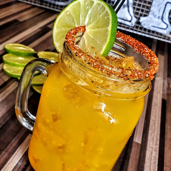 A Roadhouse sports-bar drink in a mason jar, garnished with a lime and chili-salt rim.